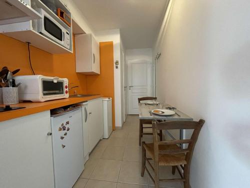 une petite cuisine avec une table et un micro-ondes dans l'établissement Studio - LA ROCHELLE LR180-059B, à La Rochelle