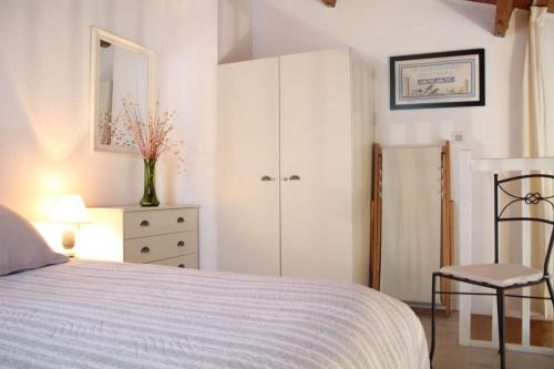 - une chambre avec un lit, une chaise et une commode dans l'établissement Appt T1 bis mezza ILE DE RE - IDR400-057, à Saint-Martin-de-Ré