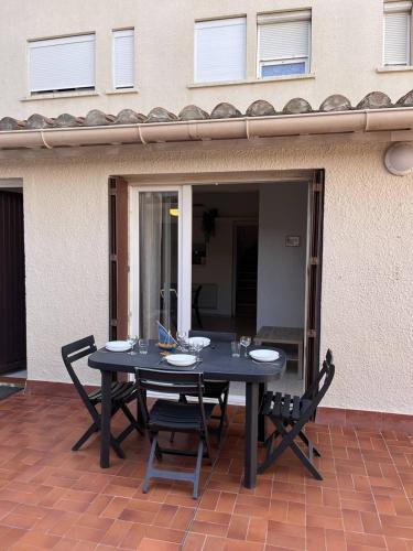 une table noire et des chaises sur une terrasse dans l'établissement Joli studio cabine en face de la Mer wifi et terrasse 4AJOU148, à Canet