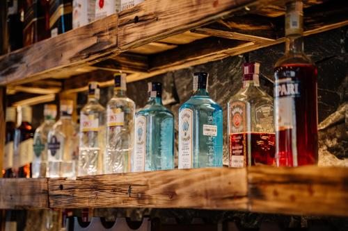 a row of bottles of alcohol sitting on a shelf at Anans Home Ha Giang - Tours & Motorbike Rental in Ha Giang