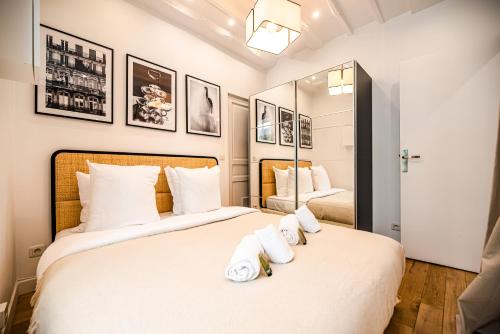 une chambre avec deux lits avec des oreillers blancs dans l'établissement CIA - Bastille Coziness, à Paris