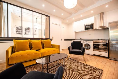 un salon avec un canapé jaune et une table dans l'établissement CIA - Bastille Coziness, à Paris
