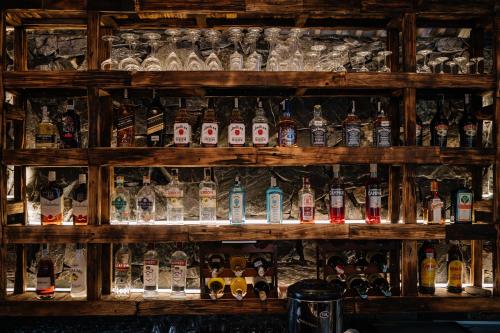a shelf filled with lots of bottles of alcohol at Anans Home Ha Giang - Tours & Motorbike Rental in Ha Giang
