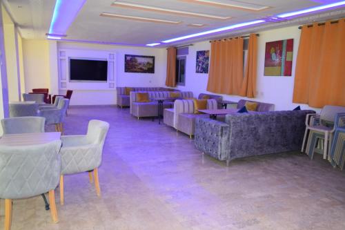 a waiting room with couches and tables and a tv at hotel el amri akchour in Akchour