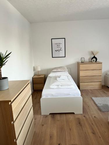 a bedroom with a white bed and wooden floors at Q Apartment No 2 in BS - stadtnah im Grünen wohnen in Braunschweig