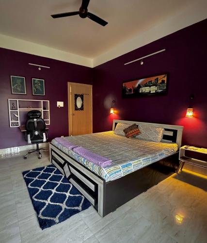 a bedroom with a large bed with purple walls at Three Little Birds Homestay in Guwahati