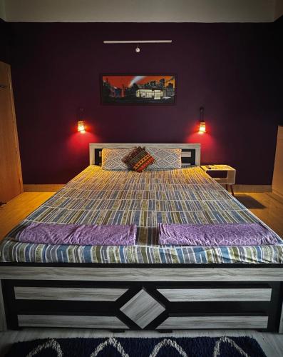a bedroom with a large bed with a colorful comforter at Three Little Birds Homestay in Guwahati