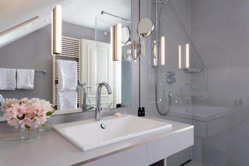 a white bathroom with a sink and a shower at Zollhaus 2 in Keitum