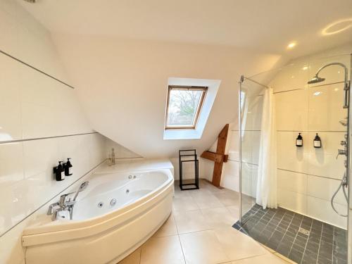 a bathroom with a large tub and a shower at Villa Nausicaa - Circuit des 24h du Mans - Piscine in Arnage