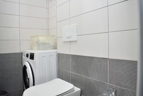 a white bathroom with a toilet and a washer at Wide Beach Apartments 236 in Mullini i Danit