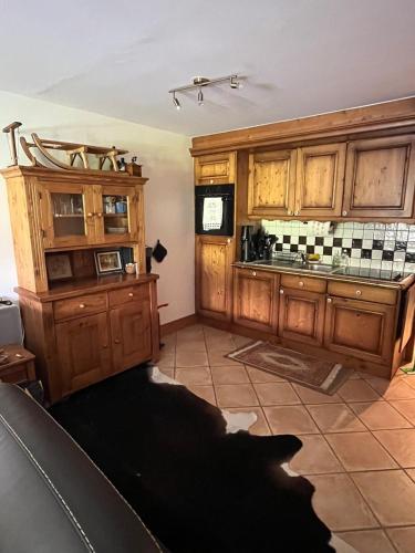 une cuisine avec des armoires en bois et un chien noir dans l'établissement The cabin at Morillon 1100, à Morillon