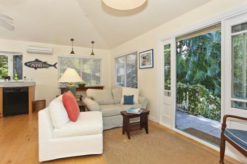 a living room with a couch and a table at The Yellow Cottage in Lanikai Your Perfect Island Getaway! in Kailua