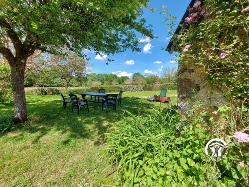 a picnic table and chairs under a tree in a yard at Mortin in Évron
