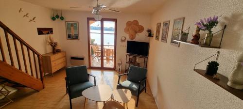 un salon avec deux chaises et une table dans l'établissement Maison de vacances unique, au bord de la mer, proche plages, à Saint Cyprien Plage