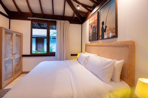 a bedroom with a large white bed and a window at Colibri Beach Villas in Ilha de Boipeba