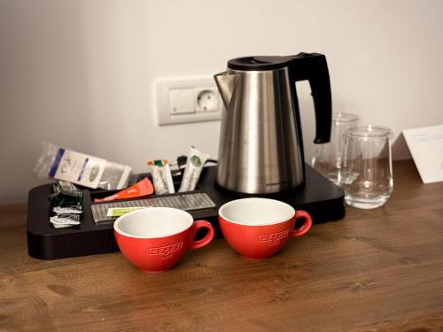 two coffee cups sitting on a counter with a coffee pot at Two Rivers Bran in Bran