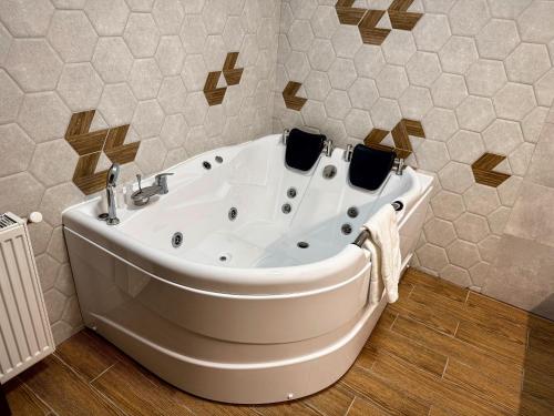 a white bath tub in a bathroom with tiles at Two Rivers Bran in Bran