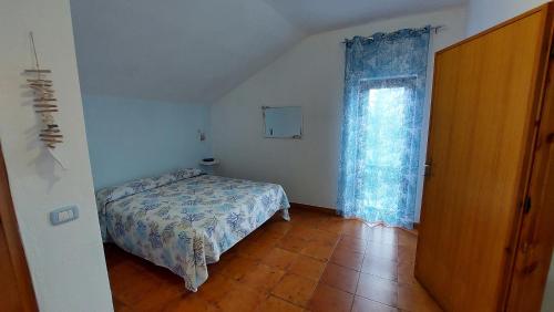 a small bedroom with a bed and a window at Villa Damiano in Tarquinia