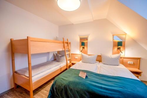 a bedroom with two bunk beds in a attic at Vakantiehotel Der Brabander Apartments in Winterberg