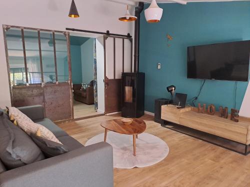 a living room with a couch and a flat screen tv at Domaine Ecoline in Sadirac