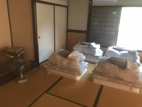 a room with three beds and a fan at Onjuku ikkyu - Vacation STAY 14021v in Hongu