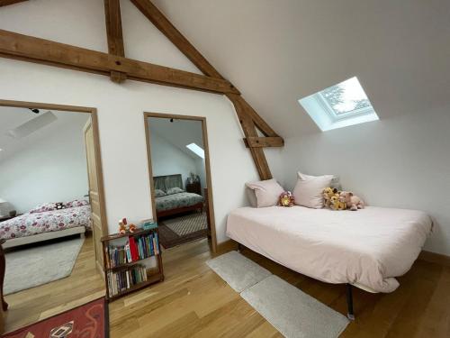 une chambre avec un lit et un grand miroir dans l'établissement Cousinade, team building, outdoor activities, à Muids