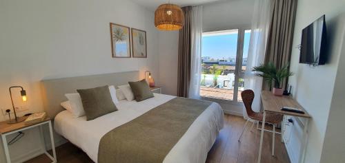 a bedroom with a bed and a desk and a window at Serena Holiday Homes by LIVVO in Playa Blanca