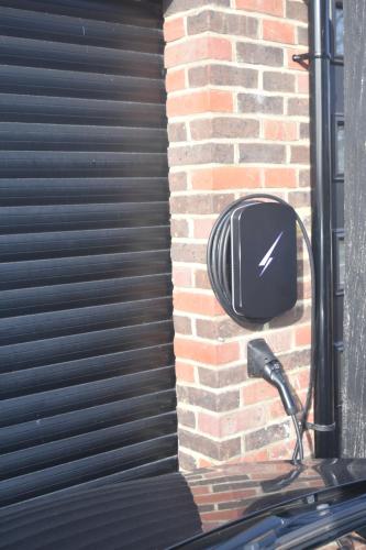 a building with a black gate with a clock on it at Spacious Garden Studio in Kings Langley