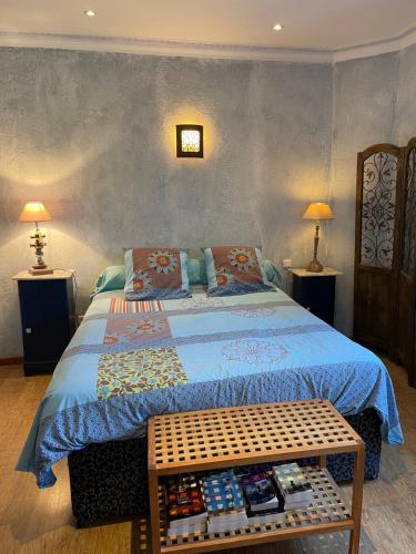 - une chambre avec un lit avec une couverture bleue et 2 lampes dans l'établissement Charmant duplex bucolique, piscine, en Provence, à Le Beaucet