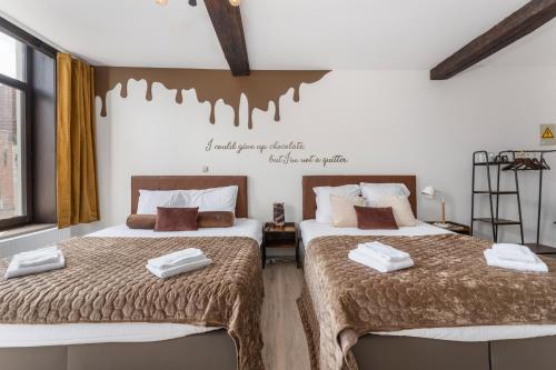 two beds sitting next to each other in a room at The Chocolate Suites in Bruges