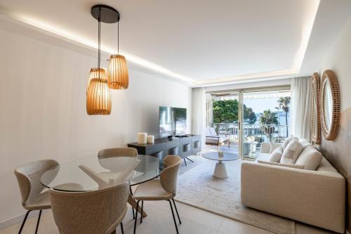 une salle à manger et un salon avec une table et des chaises dans l'établissement REF 1979 - Cannes Palm beach- Sea view apartment for rent, à Cannes