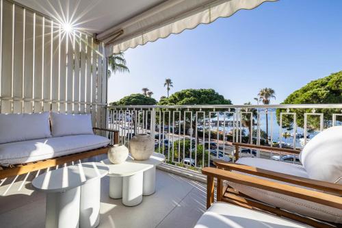 - un balcon avec un canapé et des tables dans l'établissement REF 1979 - Cannes Palm beach- Sea view apartment for rent, à Cannes