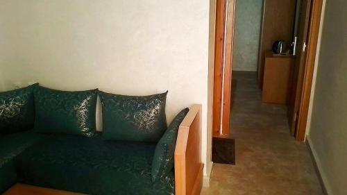 a green couch with pillows sitting in a room at hotel el amri akchour in Akchour