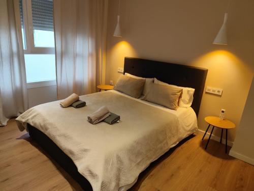 a bedroom with a large bed with two towels on it at Bazan51 1 in Alicante