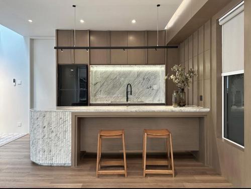 a kitchen with two wooden stools at a counter at Around Ari Hostel in Bangkok