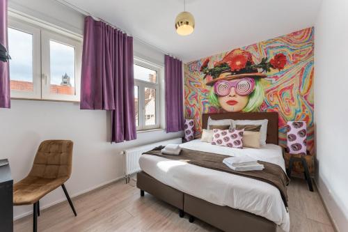 a bedroom with a bed with a painting on the wall at The Chocolate Suites in Bruges