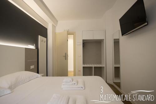 a bedroom with a white bed with towels on it at Albergo Augusta B&B in Camogli