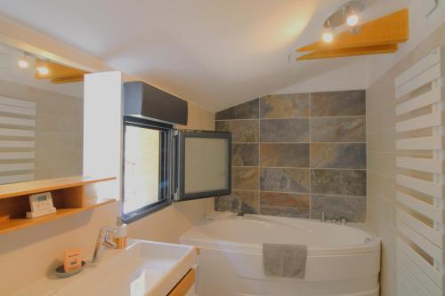 une salle de bain avec une baignoire et un lavabo dans l'établissement Villa Ceinturon-L'ayguade-50M plage CLIM PK WIFI BY HC, à Hyères