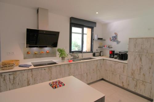 Il comprend une cuisine avec un plan de travail, un évier et une télévision. dans l'établissement Villa Ceinturon-L'ayguade-50M plage CLIM PK WIFI BY HC, à Hyères