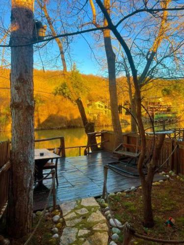 a deck with benches and a table and trees at Paradise Plus Ağva in Agva