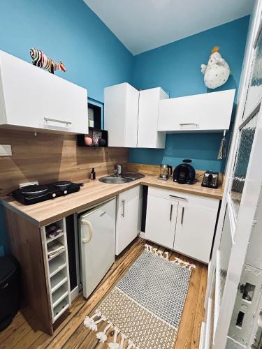 - une petite cuisine avec des placards blancs et un sol dans l'établissement Grande chambre spacieuse, à Wissembourg