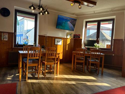 a dining room with wooden tables and chairs at Mama Zimmer in Tresdorf