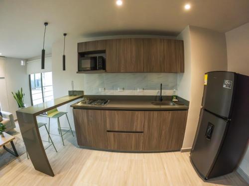 a kitchen with a refrigerator and a counter top at Santorini Apartamentos Amoblados in Pereira