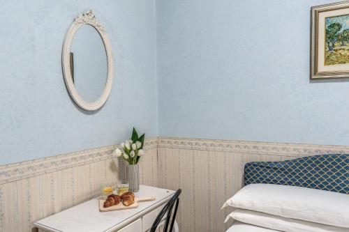 a room with a bed and a table with a mirror at Hotel Orazia in Rome