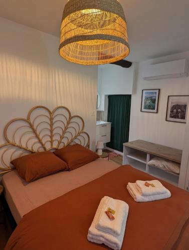 a bedroom with a large bed with towels on it at Charmant studio au coeur de la ville in Guer