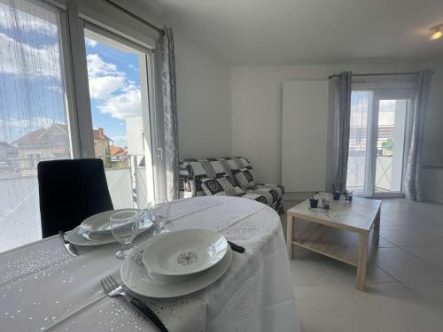 - une salle à manger avec une table et des assiettes dans l'établissement Appt 1 CHATELAILLON PLAGE CL150-123, à Châtelaillon-Plage