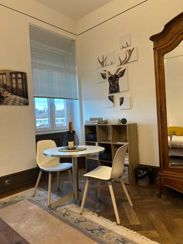 une salle à manger avec une table et deux chaises dans l'établissement Grande chambre spacieuse, à Wissembourg