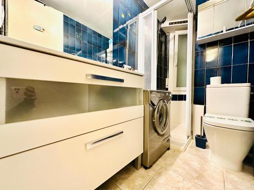 a bathroom with a toilet and a washer and dryer at Global Immo 3341 Nancy in Roses