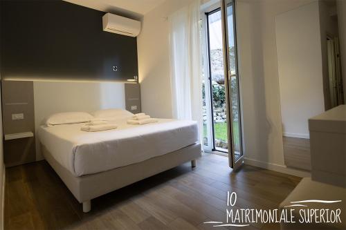 a bedroom with a white bed and a large window at Albergo Augusta B&B in Camogli