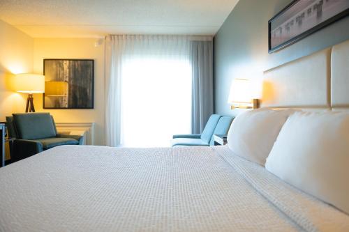 a hotel room with a bed and a chair and a window at Rodd Miramichi in Miramichi